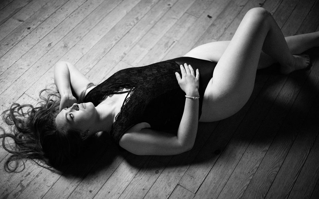 Women lying on the wooden floor black and white image - Sun is gaving over her